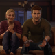 Nathan Drake and Elena Fisher sit on a couch and set the high score in Crash Bandicoot in Uncharted 4 on PS5.